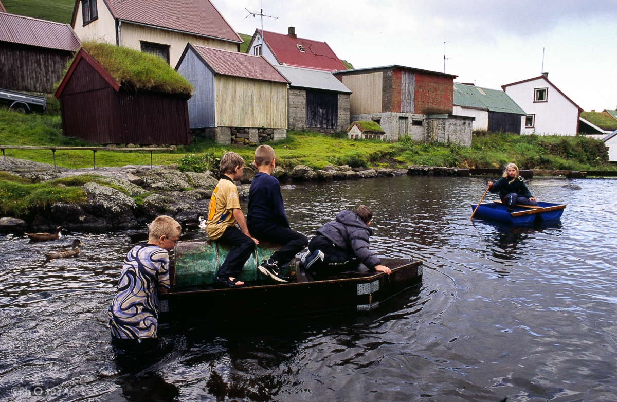 Isla de Eysturoy. Un grupo de niños juega navegando sobre "curiosas" balsas en Gjógv.