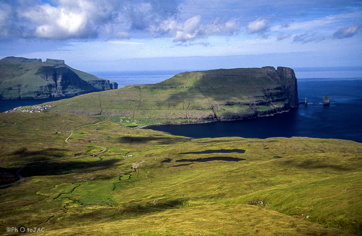 Isla de Eysturoy. Acantilados cercanos a Eidi. Los dos bloques que aparecen a la derecha son conocidos como "Risin" (71m, dcha.) y "Kellingin" (68m, izqda.), que traducido es "el gigante y la bruja". Hay una antigua leyenda sobre su origen.