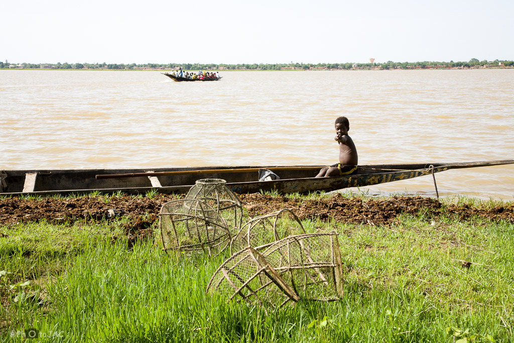 Segou (Mali). Embarcación típica, conocida con el nombre de pinaza, en aguas del río Niger, con un niño a bordo y nasas en primer término.