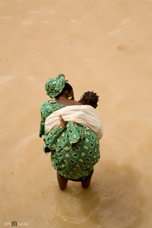 Mali: Puerto de Mopti. Mujer con su hijo en el interior del río Niger.