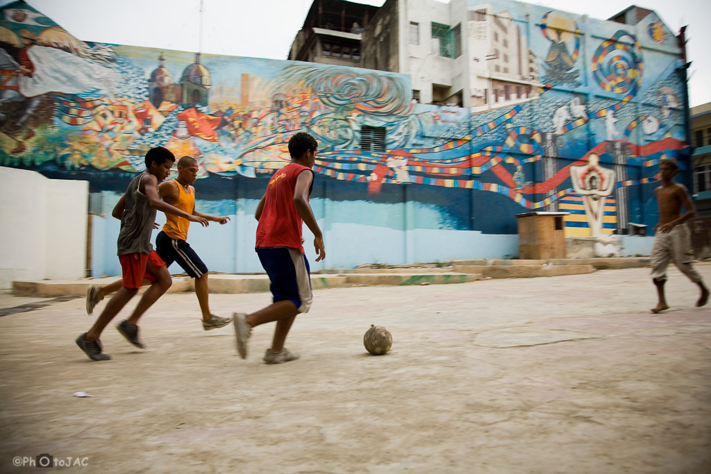 Santiago de Cuba: Niños juegan al futbol en una plaza céntrica.
