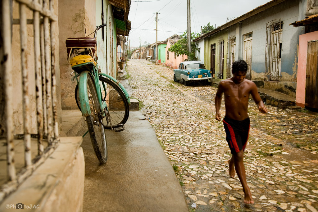 Trinidad (provincia de Sancti Spíritus). Calles empedradas del casco antiguo. Un joven corre para guarecerse de la lluvia que cae en estos momentos.