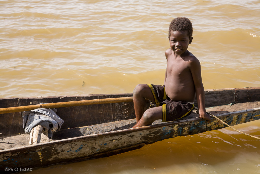 Segou (Mali). Embarcación típica, conocida con el nombre de pinaza, en aguas del río Niger, con un niño a bordo.