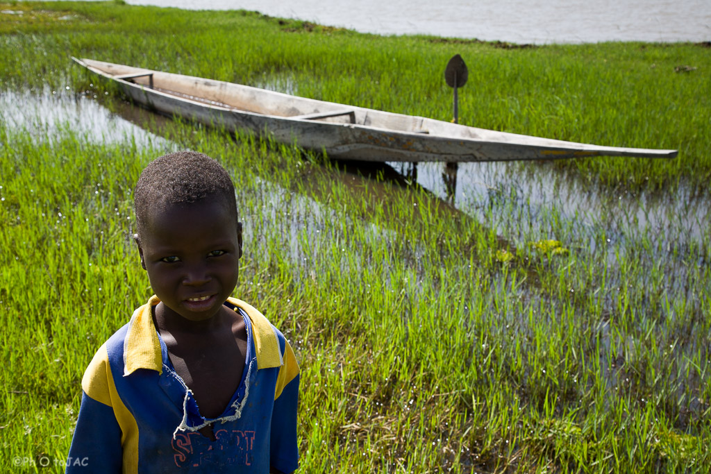Niño en una pequeña aldea, de etnia "bozo" (mayormente pescadores), enfrente de la ciudad de Segou, en la otra orilla del Niger. La embarcación es conocida como "pinaza". Mali.