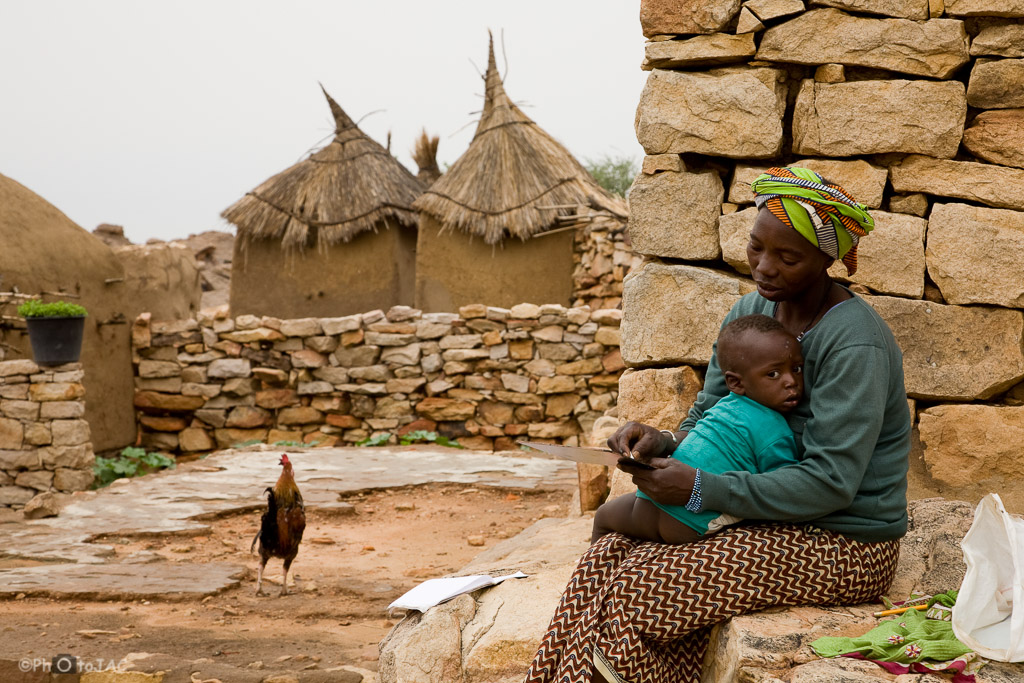 País Dogón. Mali. Viviendas y graneros erigidos con madera, adobe y piedra en la aldea de Daga. Madre con su hijo.