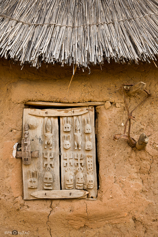País Dogón. Mali. Aldea de Begnimato. Fachada de un granero erigido con madera y adobe. Detalle de la puerta de madera de una ventana bellamente tallada.