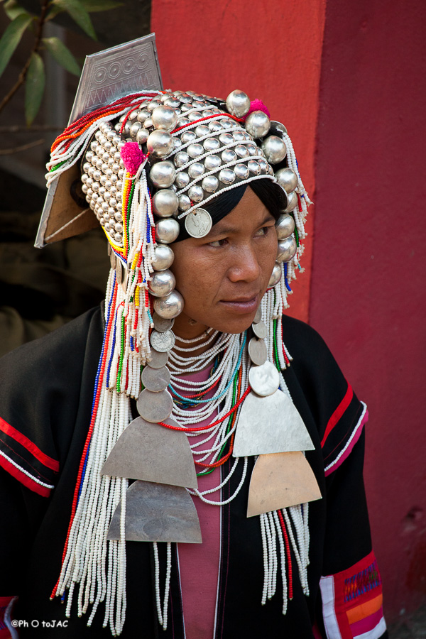 Mujer de la etnia "Akha", con su vestimenta tradicional, cuyo sombrero está adornado con monedas de plata, en el mercado matinal en Mae Salong.