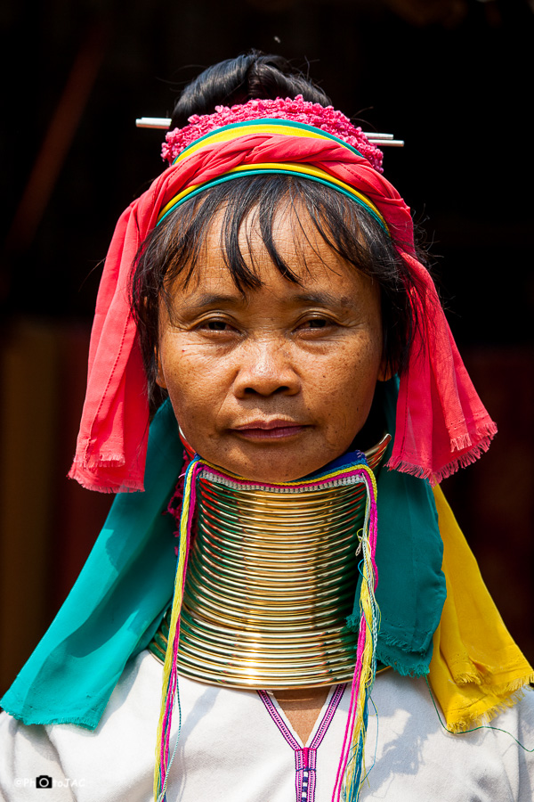 Mujer de la etnia "Padaung" (o "Red Karen"), subgrupo de la etnia "Karenni", ubicada en la frontera entre Birmania y Tailandia. Utilizan una pesada espiral de latón alrededor de sus cuellos con el fin de alargarlos. Aunque esto era simple tradición, actualmente muchas los portan para atraer turismo y conseguir ingresos, ya que el estatus de esta etnia en Tailandia es de refugiados.